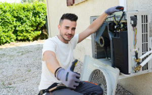 Handsome Young Man Electrician Installing Air Conditioning In Client House